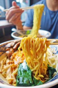 My Jidori Mazemen (Jidori chicken, chili granola, poached egg, bean sprouts, menma, spinach, chewy noodles) in the foreground and his Yuzu Dashi (Shio base, fresh yuzu seasoned chicken broth, chashu pork, menma, spinach, scallion, nori, thin noodles) in the background.